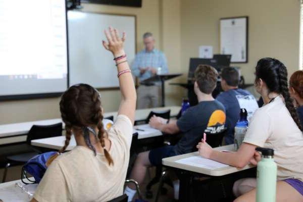 Student raising hand in classroom